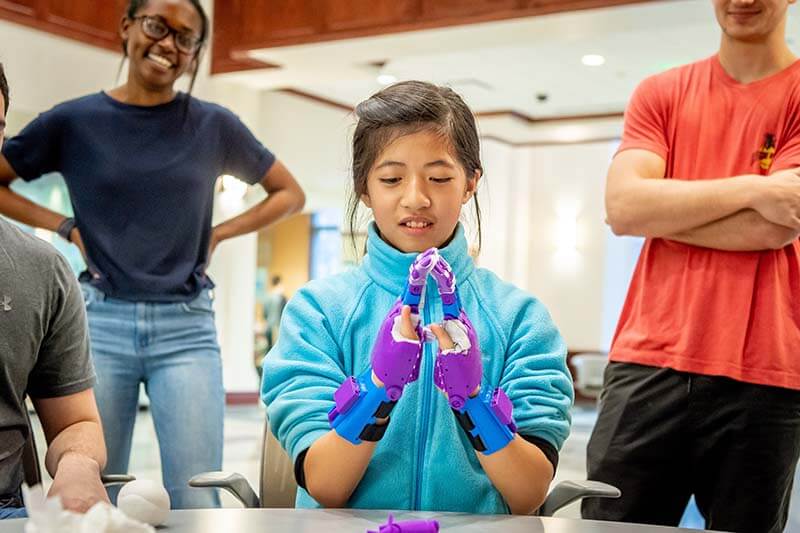 Tori tries the first of a pair of 3D-printed prosthetic hands.