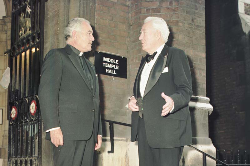 Father Hesburgh talks with Chief Justice Warren Burget outside of Middle Temple. A sign on the building reads, 'Middle Temple Hall'.