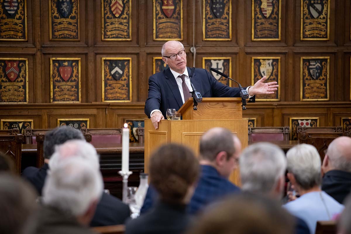 Lord Neuberger speaks at a podium to a crowd.