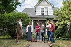 A group of researchers stand in front of a South Bend home with lead testing kits.