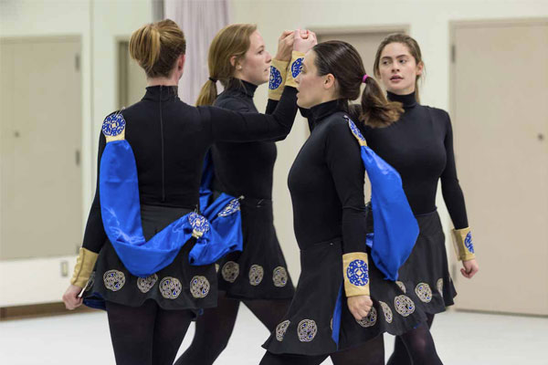 4 females dressed in black move around in a circle.