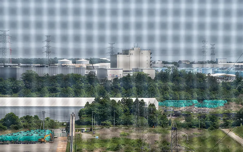A view of Fukushima Daiichi Nuclear Power Plant through a screen from a distance.