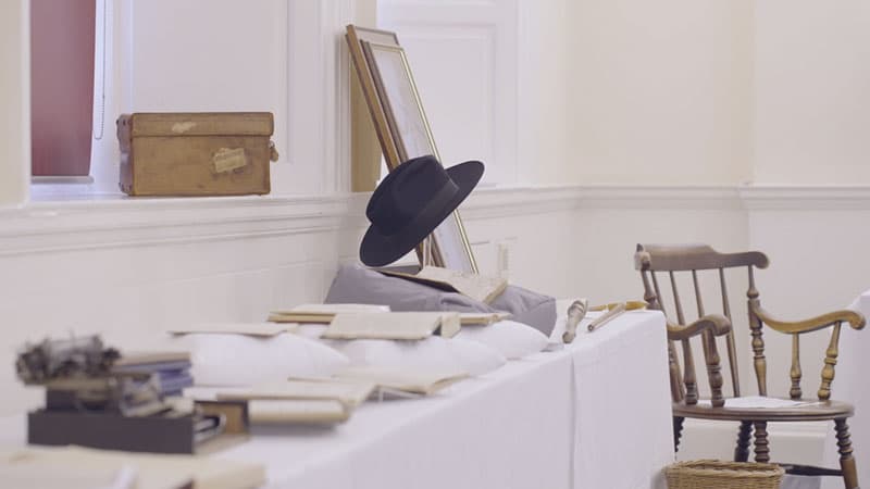 Some of the items in the G.K. Chesterton collection, including a hat, chair, and books and documents.
