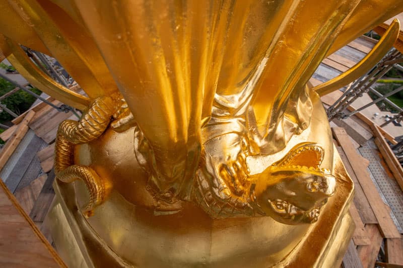 A close up of the serpent, half globe, and cresent at the base of the statue of Mary on top of the Golden Dome.