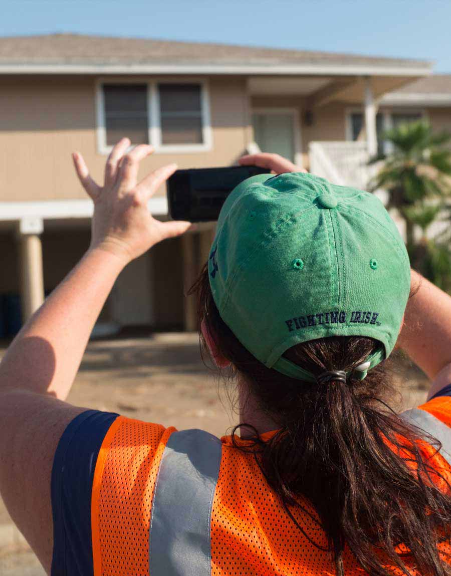 Kijewski-Correa assessing homes and documenting photos on her phone.