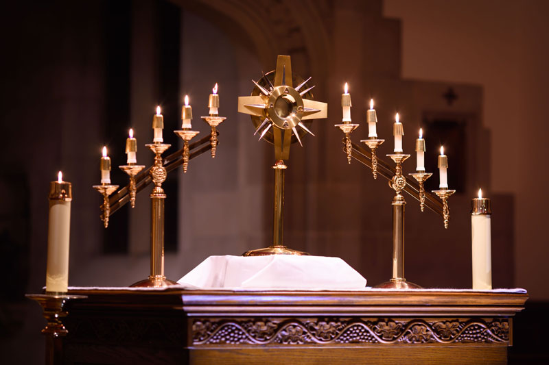 The Eucharist surrounded by candles on an altar