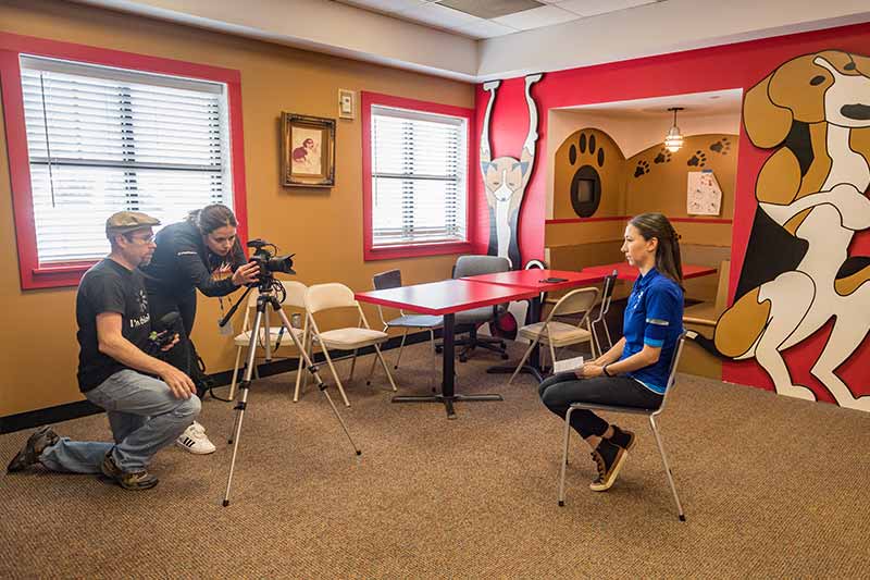 Student journalist Kelli Smith sets up her camera with Eric Nisly to interview Lisa Tynan, community outreach manager at Houston SPCA. 