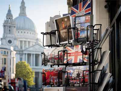 London postcards on a rack in front of a historical building