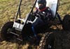 Notre Dame student engineer in dune buggy with custom parts made by the machinists.