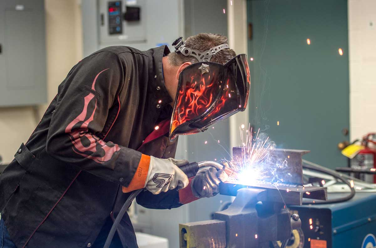 Mike Sanders welds in his workshop as sparks fly at Hessert Lab.