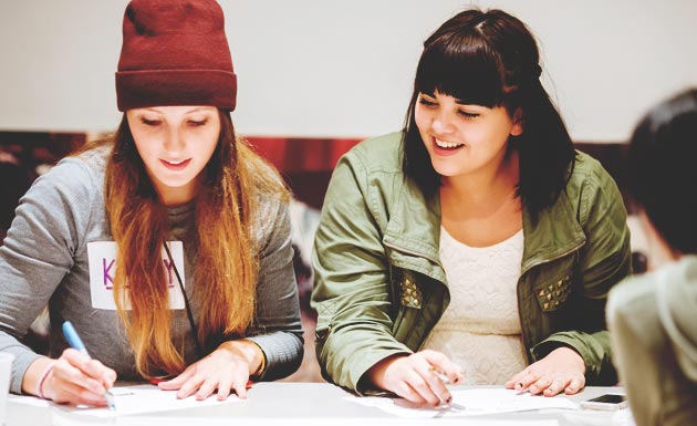 Two female students working at a table