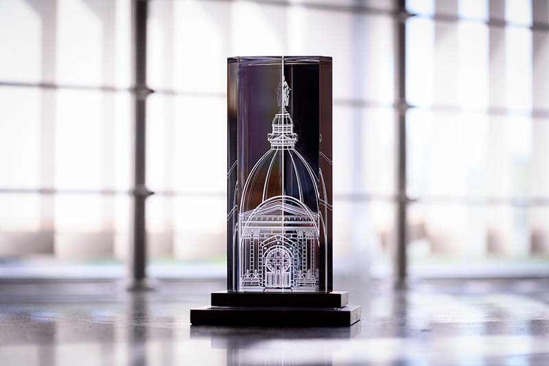 A clear award with the Dome etched in it sit on a table.