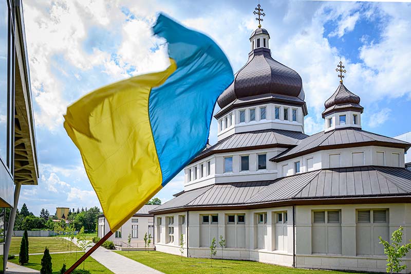 Church at Ukrainian Catholic University with the Ukraine flag blowing in front of it.