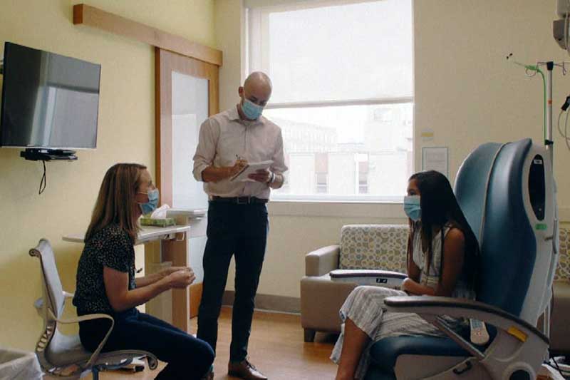 A physician meets with a patient in a doctor's office.