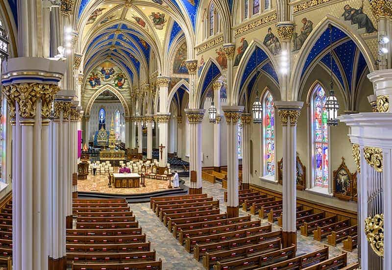An empty Basilica of the Sacred Heart, a priest is livestreaming a service.