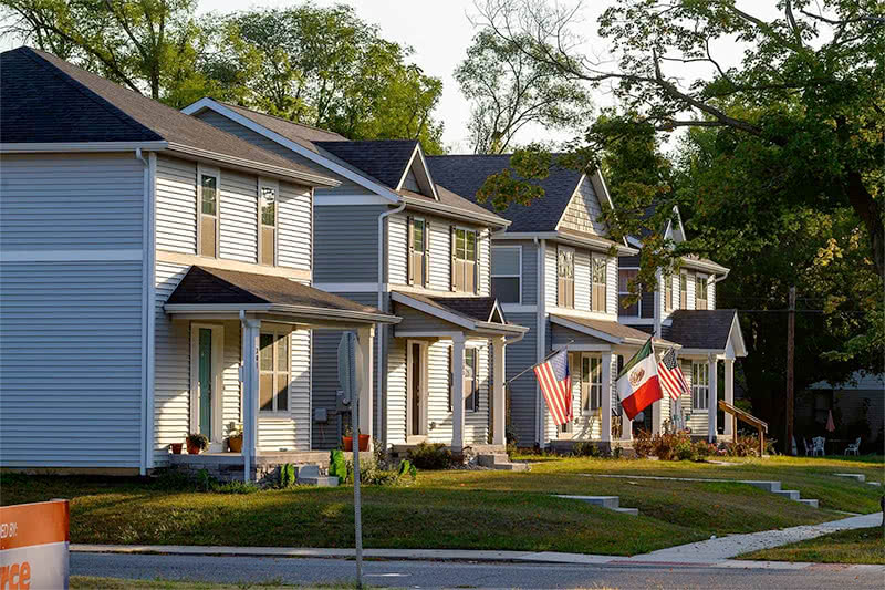 Side angle view of 4 identical houses in a neighborhood.