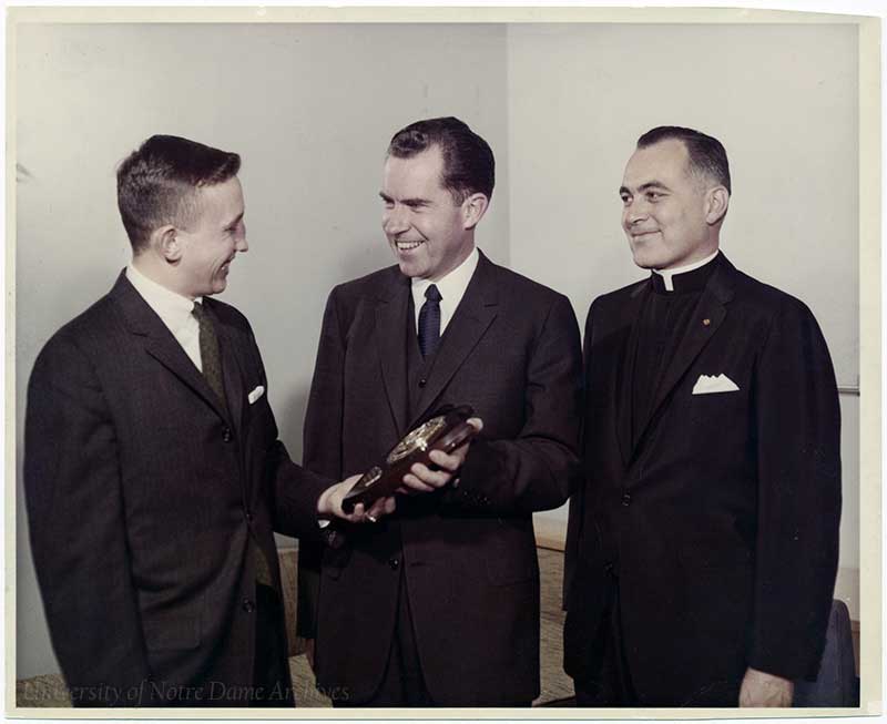 Vice President Richard Nixon receiving the Patriot of the Year Award from Senior Class President Richard Corbett, with Rev. Theodore M. Hesburgh, C.S.C., 1960.