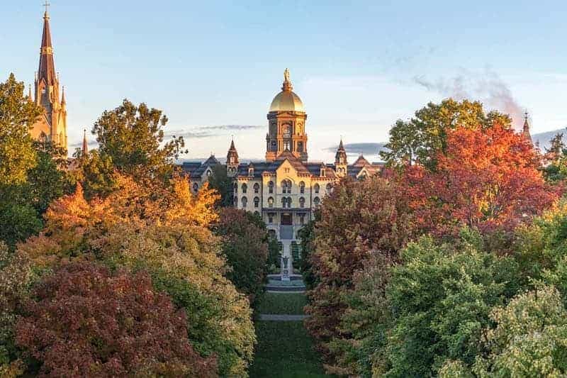 The Main Building Golden Dome surrounded by fall leaves.