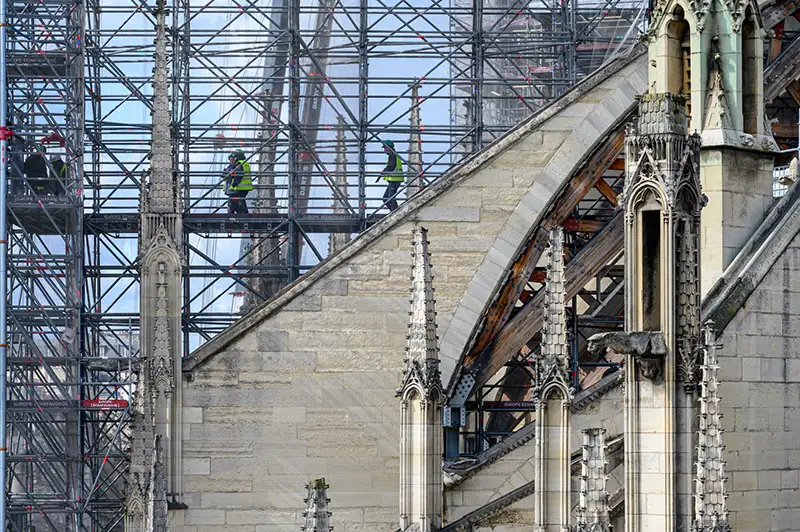 A view of the cathedral's flying buttresses being supported by custom-made wooden frame during restoration.