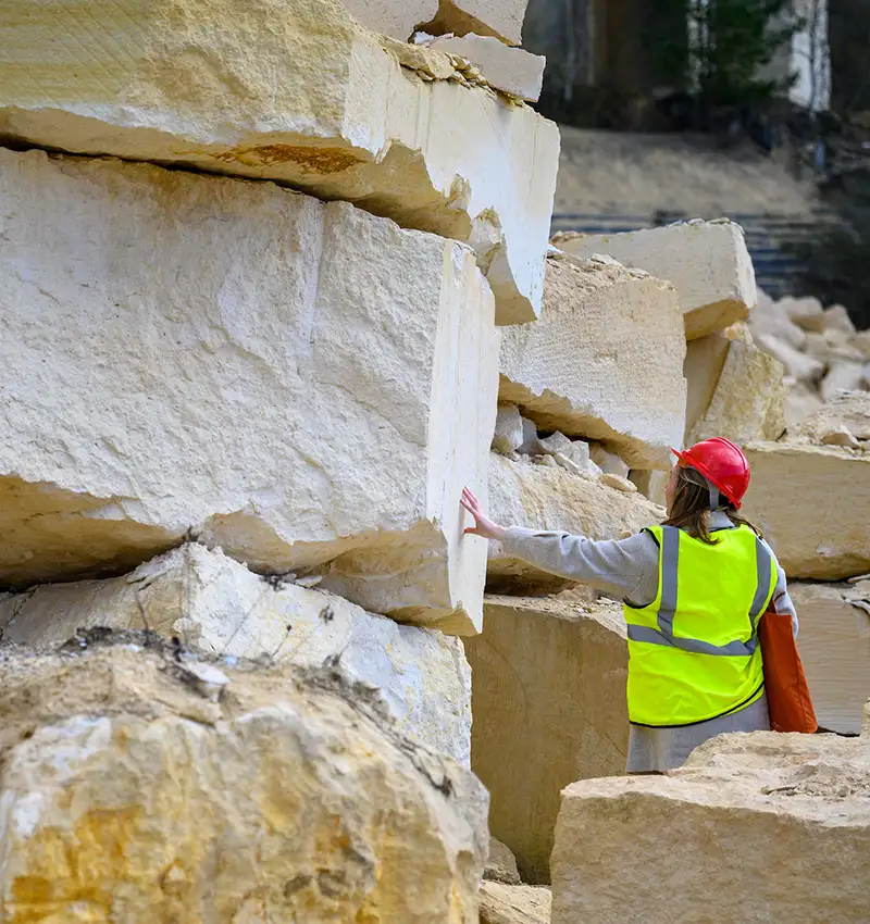 A Notre Dame architecture student reaches out to touch a large cut stone to get a feeling of size and scale.