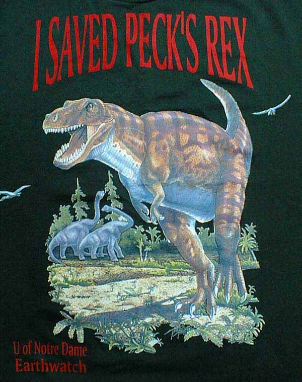 A dark green shirt with a Tyrannosaurus Rex. Above the T-Rex, 'I saved Peck's Rex' is printed on the t-shirt. 'U of Notre Dame Earthwatch' at the bottom left.