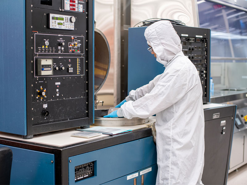 A person in a hazmat suit works in the clean room.