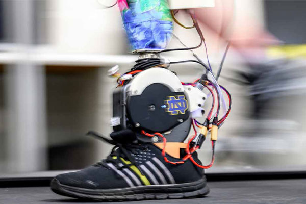 A slightly blurred moving powered prosthetic ankle mimics the movement of a real foot.