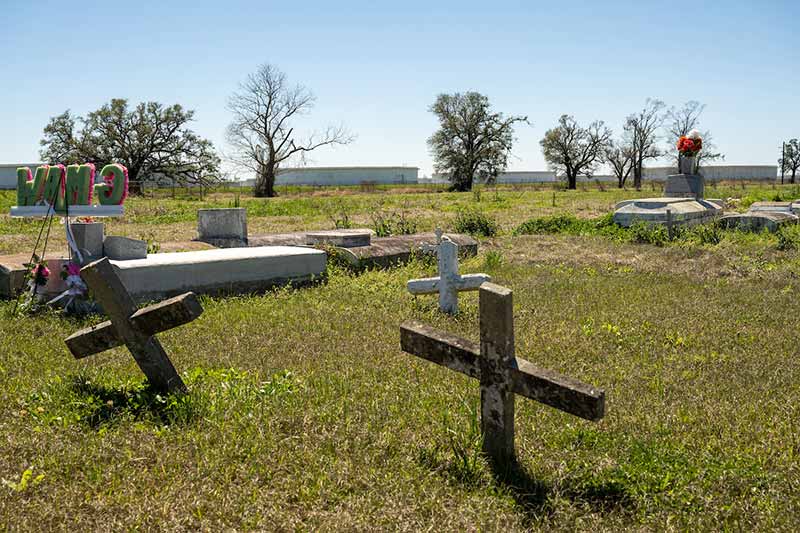 Scattered crosses and stones in a small cemetery.