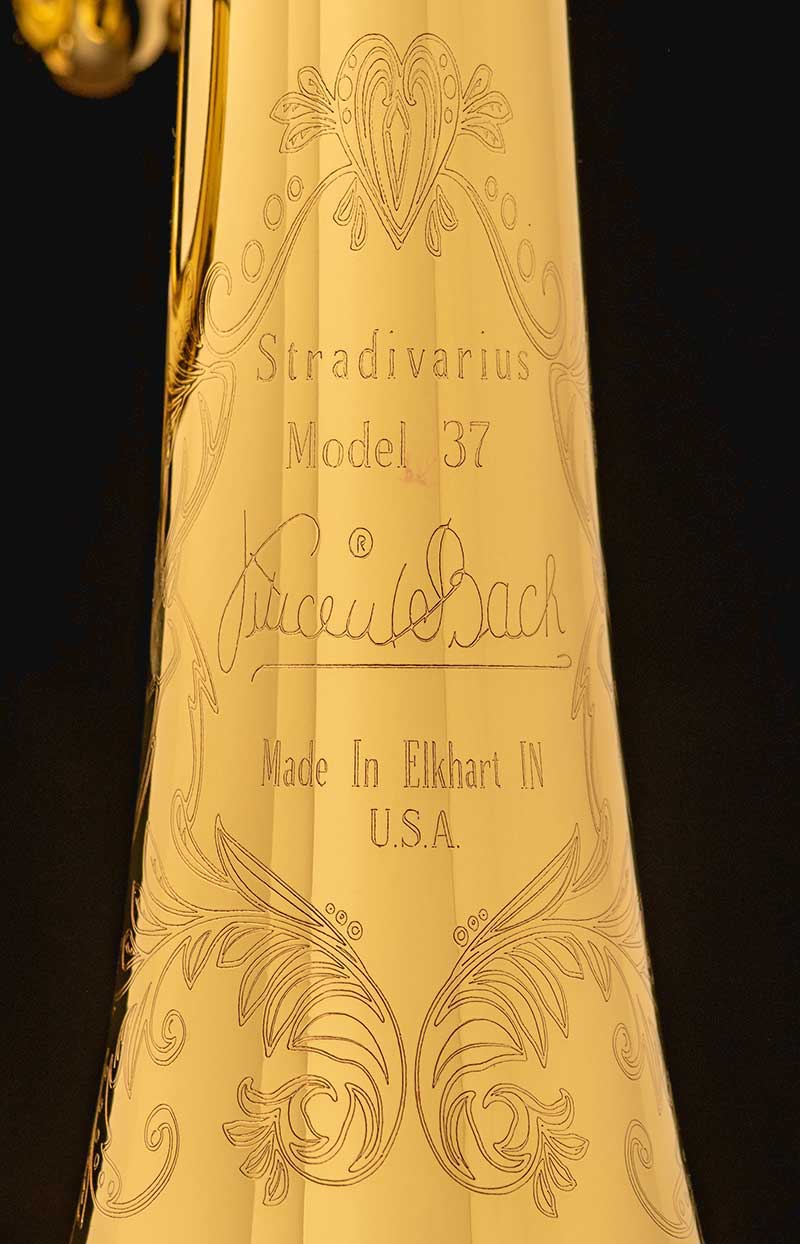 On a black background, Stradivarius Model 37, Make in Elkhart IN USA etched on a trumpet.