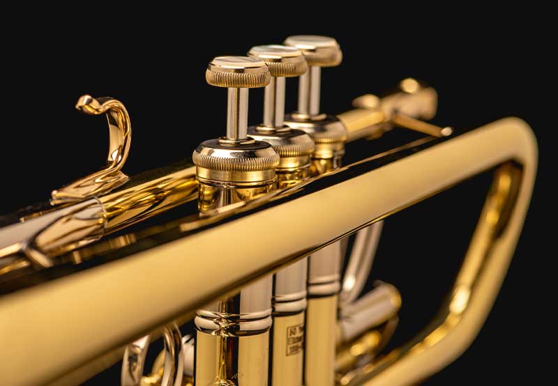 On a black background, a close up of a trumpets valves.