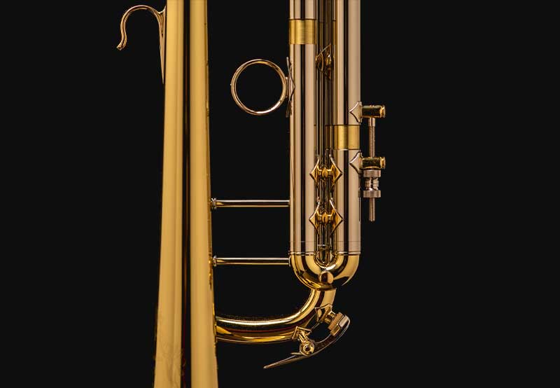 On a black background, a trumpet's slides are viewed from it's side.