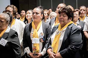 Sorrowful mothers wearing yellow scarves and pins when faces of the missing.