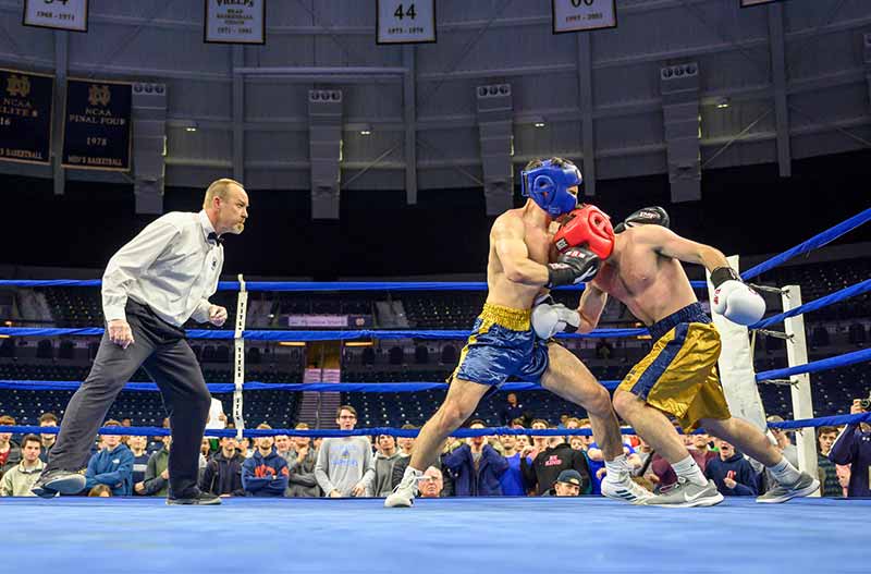 Two young men box in a boxing ring.