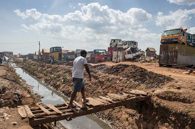 YYALI fellow Alex Kawooya crosses a foot bridge in Kalerowa slum where he lived for 11 years.