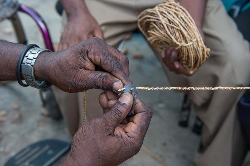 Close up shot of landmine victims make rope out of banana fiber.