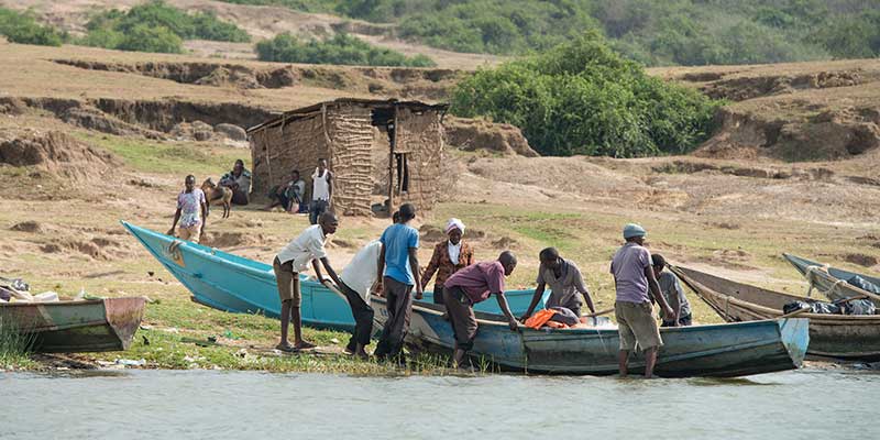 Ugandans from a fishing village in Queen Elizabeth National Park launch their boats.