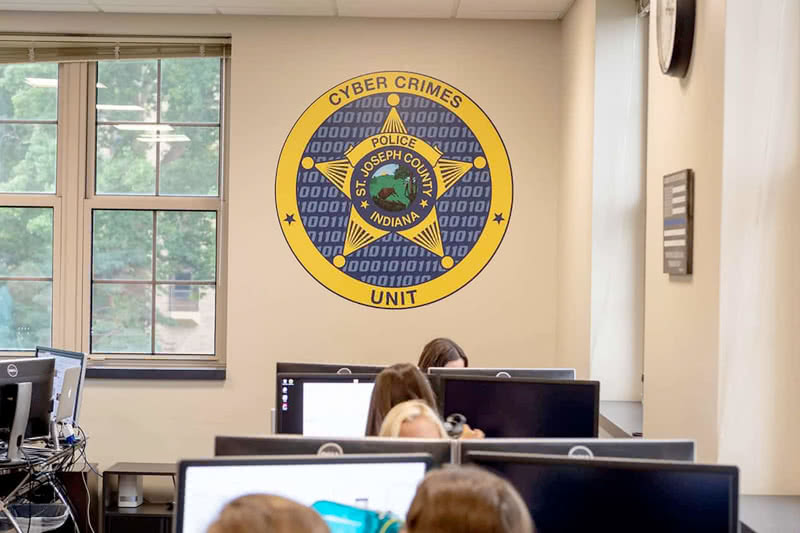 Room with a large seal on the wall reading: St. Joseph County, Indiana Cyber Crimes Unit